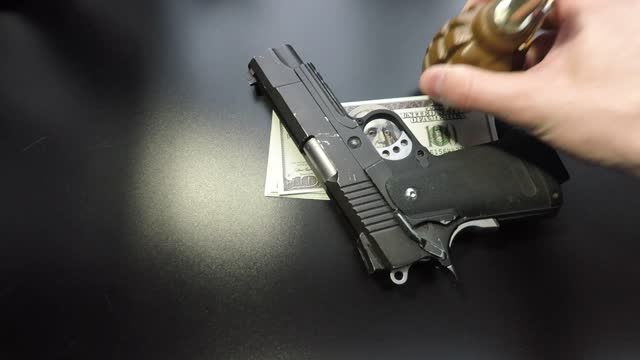 money pistols and hand grenade on black background