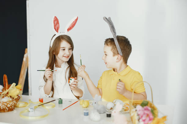 istock Children paint eggs and prepare for Easter in festive clothes 1305520245