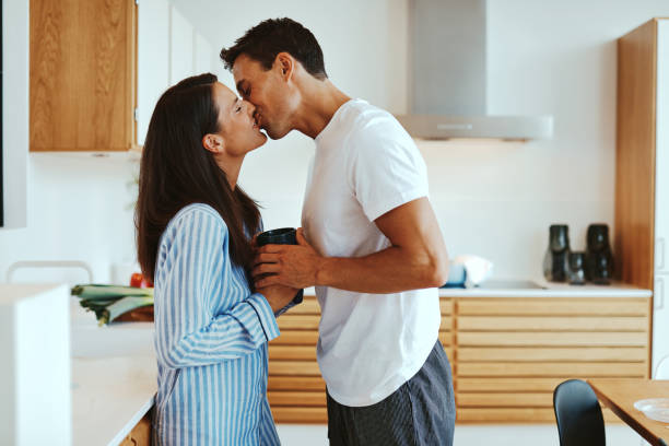 istock Couple kissing over coffee at home 1305520878