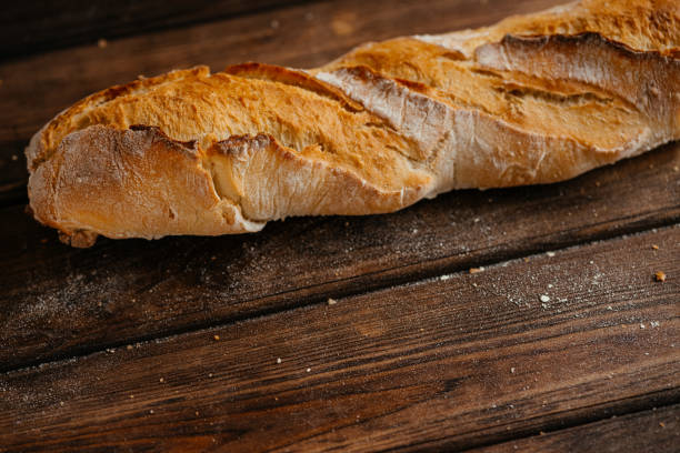 istock baguette on a wooden brown background 1305522181