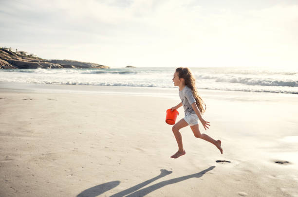 Child playing on tropical beach. Little boy with bucket and spade at sea shore. Family summer vacation. Kid building sandcastle. Water and sand fun for children. Kids play, build castle on ocean coast