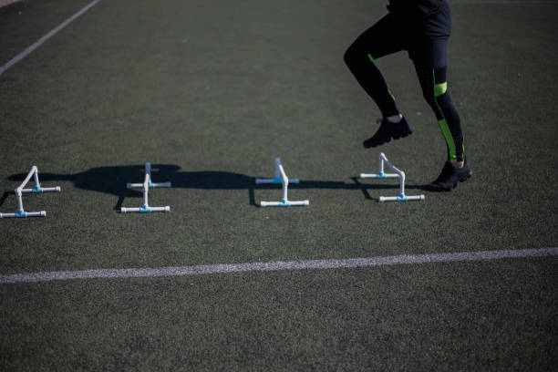 istock Athlete stepping over mini hurdles stock photo 1305523033