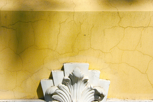 Estilo neobarroco viejo pintado pared amarilla de construcción con adornos de escultura photo