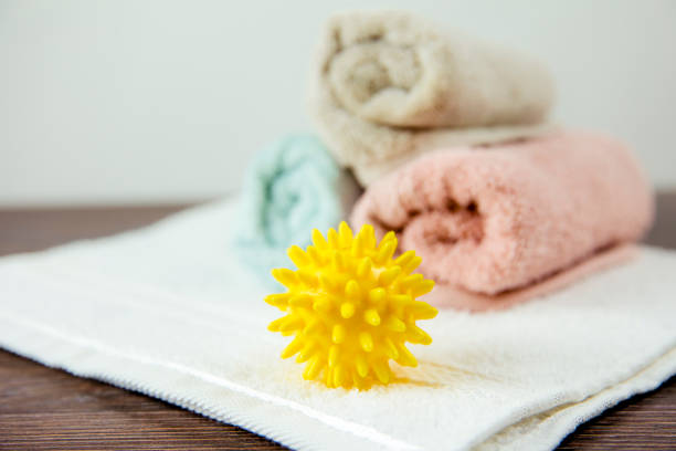 Natural fabric softener spiky dryer ball for more soft clothes while tumble drying concept. Natural fabric softener spiky dryer ball for more soft clothes while tumble drying concept. tumble dryer stock pictures, royalty-free photos & images