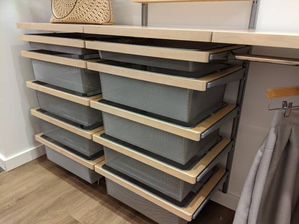 Angled view of a set of wire mesh drawers inside a large walk in closet Angled view of a set of wire mesh drawers inside a large walk in closet with wooden floors wood closet organizers stock pictures, royalty-free photos & images