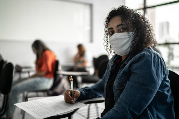 istock Portrait of a student studying in classroom - wearing face mask 1305527949