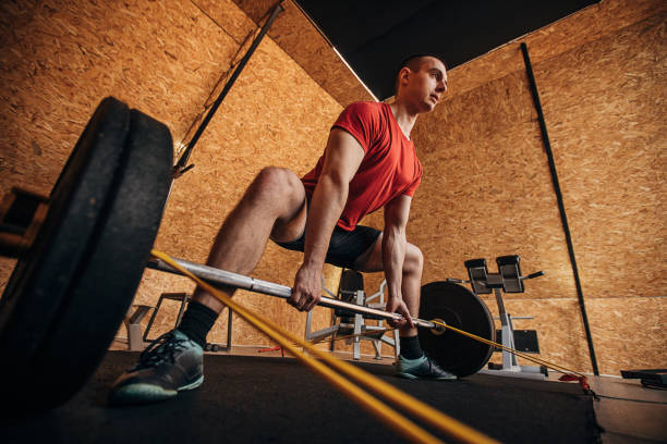 istock Man exercising with weights in gym 1305528048