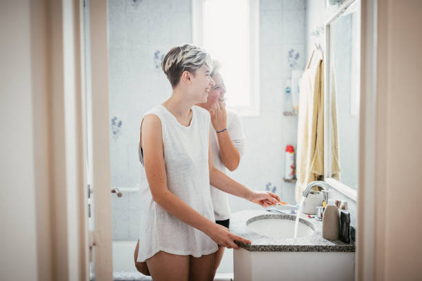 istock Lesbian couple in bathroom in the morning, brushing teeth before going to work 1305530537