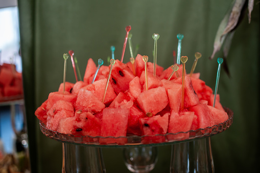 Fruit slicing at a wedding banquet. Watermelon, grapes, strawberry, orange, plum, pear, dinha, peach, kiwi, pineapple, persimmon, apple