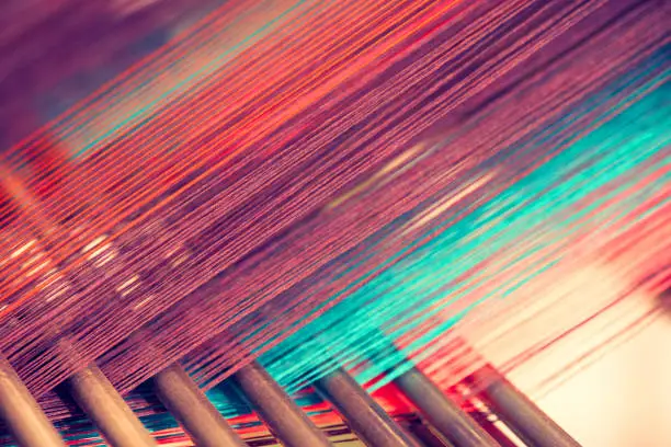 Photo of Multicolored straight strands texture background, sewing equipment, loom equipment at a garment factory