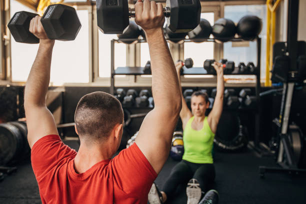 istock Man and woman exercising together 1305534300