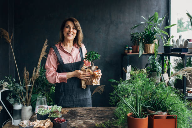 istock Gardening as a Hobby: a Senior Woman Holding a Bonsai Tree 1305536424