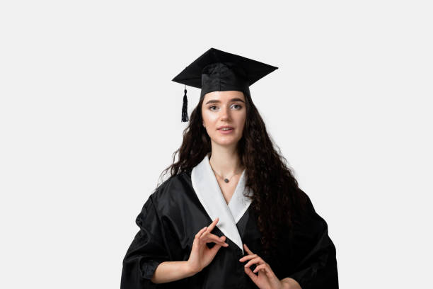 istock Distance learning online. Study at home. Graduation from college. Graduate in black robe smile on white background. Funny woman smiling after successful finish university and complete master degree 1305538012