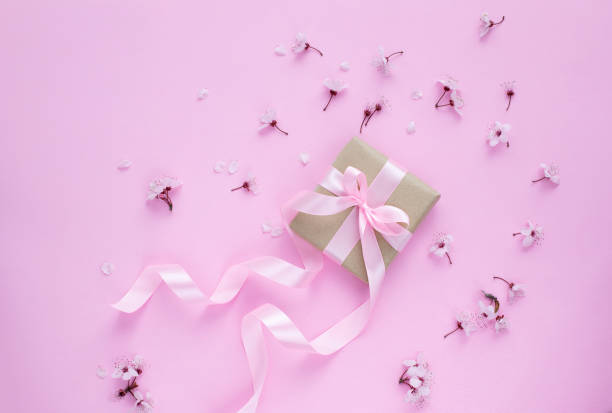 istock Cherry blossom and gift box with pink ribbon on pink background 1305538231