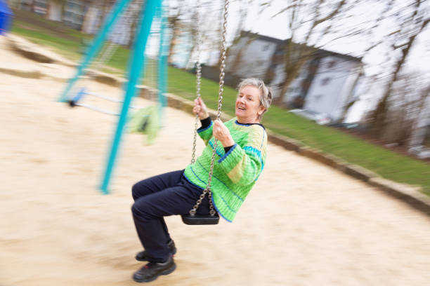 istock Senior woman having fun on a swing 1305540199