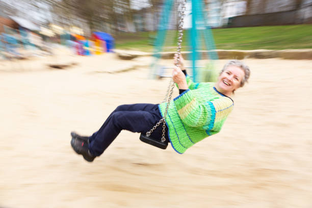 istock Senior woman having fun on a swing 1305540207