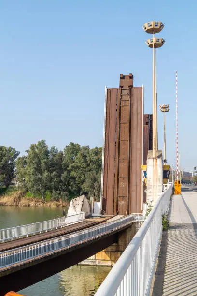 Modern drawbridge railway next to Puente de las Delicias for the transport of goods from the port of Seville (Andalusia, Spain). Drawbar tracks on the Guadalquivir river.