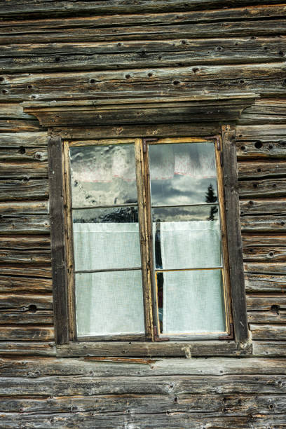 istock Old skewed and tilted window in an old timber wall 1305541910