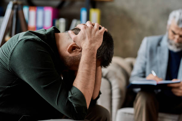 istock Upset man sitting near psychotherapist during appointment 1305543088