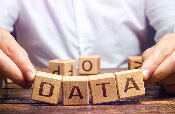 istock The man tries to pick up blocks with the word Data. Digital data integrity and security vulnerability concept. Fault tolerance, backup. Financial data leakage, password draining. Increased reliability 1305543155