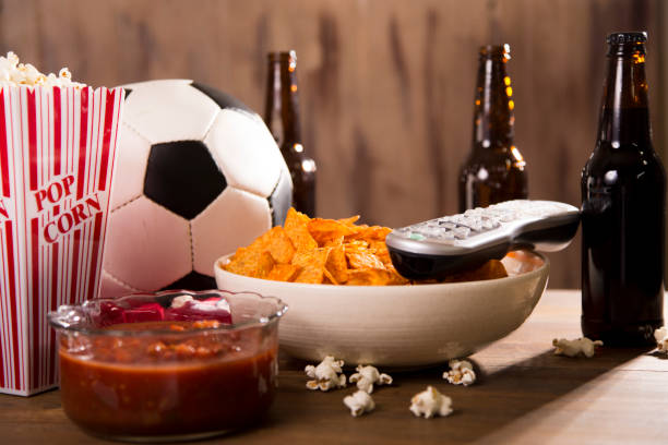 смотрю футбольный матч с закусками, напитками. - cashew beer nuts nut food стоковые фото и изображения