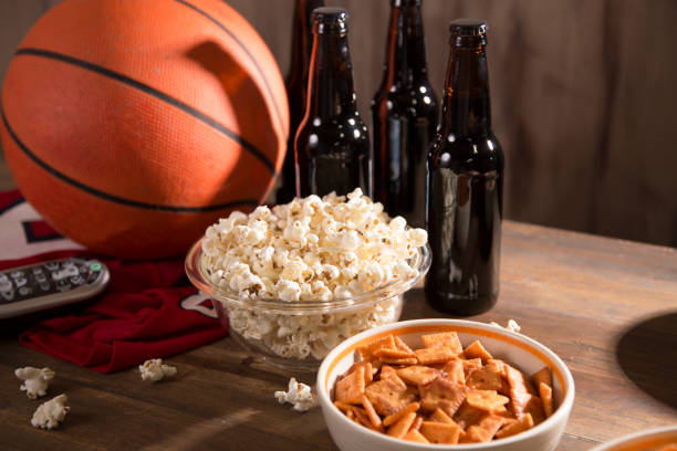 смотрю баскетбольный матч с закусками, напитками. - cashew beer nuts nut food стоковые фото и изображения