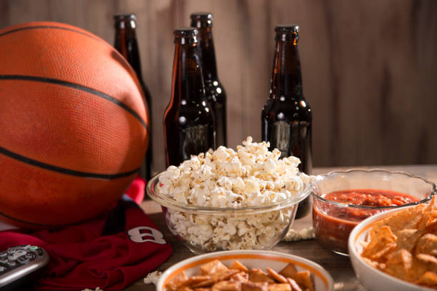 oglądanie gry w koszykówkę z przekąskami, napojami. - cashew beer nuts nut food zdjęcia i obrazy z banku zdjęć