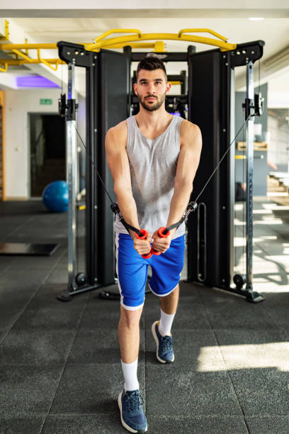 istock Young strong man  doing flys on cable crossover in gym 1305550463