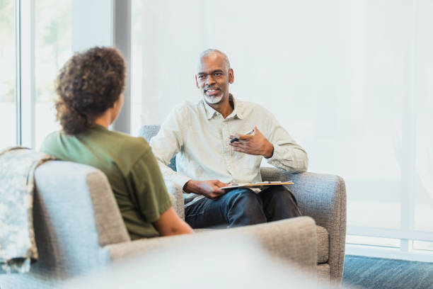 istock Male counselor gestures while sharing with unrecognizable soldier 1305552421
