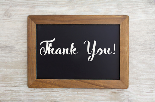 Thank you written on a black chalk board with a wooden frame, stock photo.