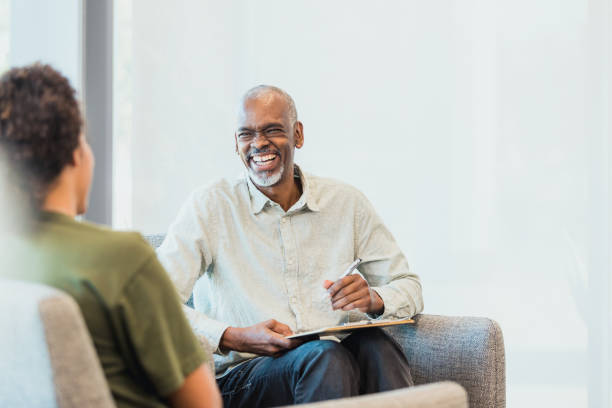 istock Mature male financial advisor shares laugh with unrecognizable client 1305552519
