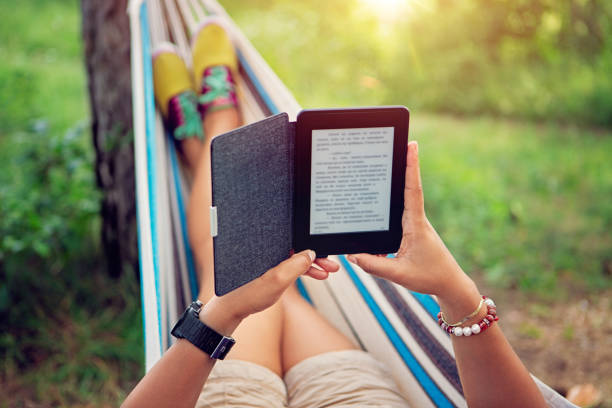 Woman is reading e-book in a hammock