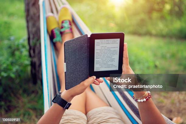 Woman Is Reading Ebook In A Hammock Stock Photo - Download Image Now - E-Reader, Summer, Book