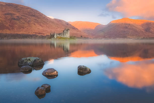 Kilchurn Castle. Loch Awe, Scotland Scottish Highlands landscape of the historic ruins of Kilchurn Castle reflected on a calm, peaceful Loch Awe with sunset or sunrise golden light. argyll and bute stock pictures, royalty-free photos & images
