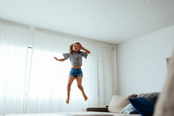 istock Young Girl playing on sofa 1305561397