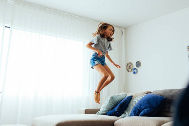 istock Young Girl playing on sofa 1305562928