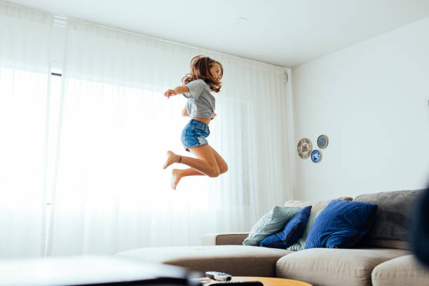 istock Young Girl playing on sofa 1305563743