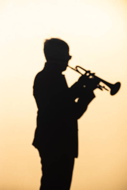 istock Trumpet Player Sunset Silhouette Young Man playing Trumpet 1305565449