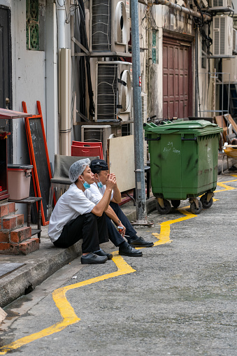 Singapore, November 24, 2021: Two man taking a smoking break downtown Singapore
