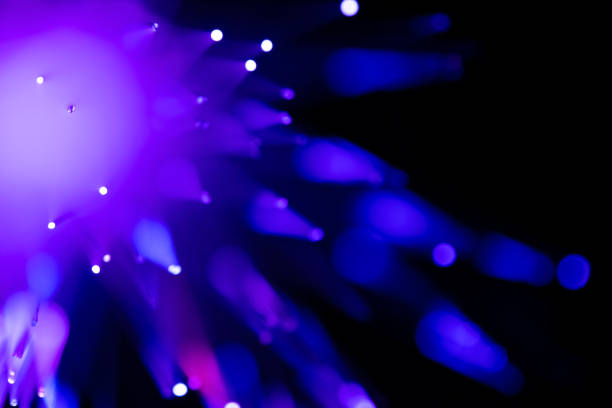 purple optical fibre in dark selective focus - facula imagens e fotografias de stock