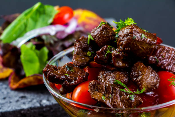 istock Sliced grilled beef barbecue steak and salad with tomatoes and arugula 1305577653