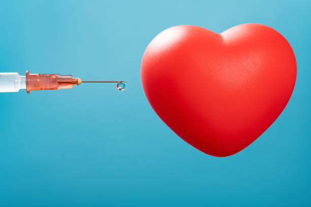 syringe and a heart model on blue background