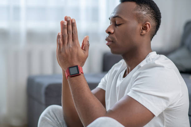 istock Handsome african american guy meditating and looking calm 1305580265