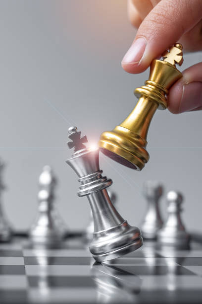 istock businessman hand moving gold Chess King figure and Checkmate opponent during chessboard competition. Strategy, Success, management, business planning, disruption and leadership concept 1305583821