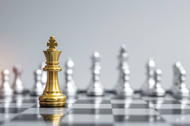istock Gold Chess king figure on Chessboard against opponent or enemy. Strategy, Conflict, management, business planning, tactic, politic, communication and leader concept 1305583840