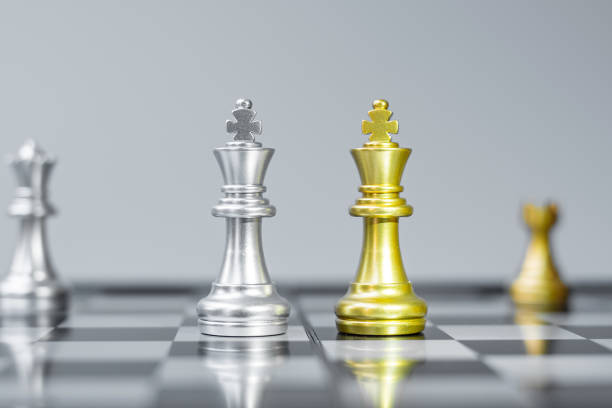 istock Gold and silver Chess King figure on Chessboard against opponent or enemy. Strategy, Conflict, management, business planning, tactic, politic, communication and leader concept 1305584679