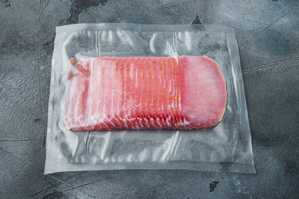istock Dried pork meat slices, vacuum packed, on gray stone background 1305592787