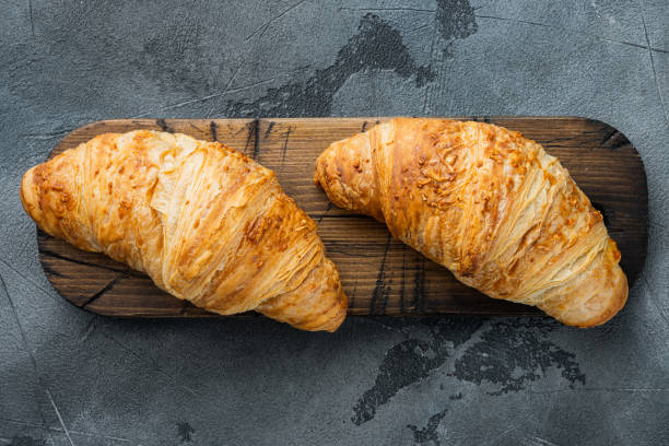 istock Crispy fresh croissants, on gray stone background, top view flat lay 1305592808