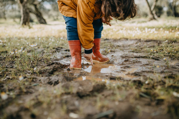 istock Low Section Of Child Standing In Mud 1305603742
