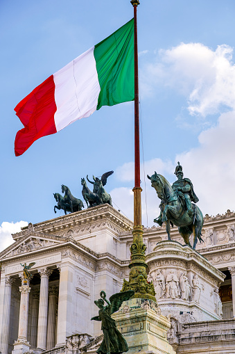 The Italian tricolor flag flies over the Altare della Patria National Monument in the historic center of Rome near the Capitoline Hill (Campidoglio) and Piazza Venezia, built between 1885 and 1935 in honor of the first King of Italy, Vittorio Emanuele II. Inside there is the Unknown Soldier grave, the National Memorial Monument dedicated to all Italian soldiers who died in wars. The Altare della Patria is the setting for all the official Italian celebrations, in particular the National Day of the Republic on 2 June and the Liberation Day on April 25th. Image in High Definition format.